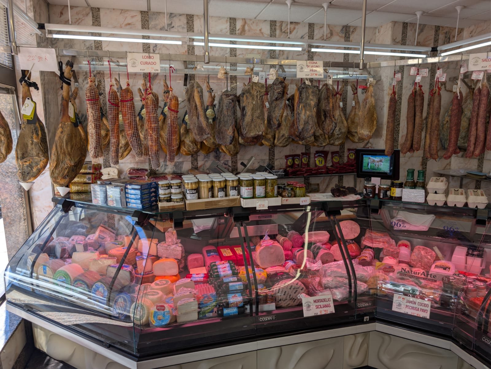 El mostrador de Carnicería Merino en Astorga, con jamones y embutidos colgados